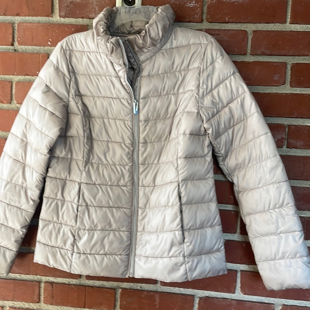 Women’s tan / beige colored puffer jacket.